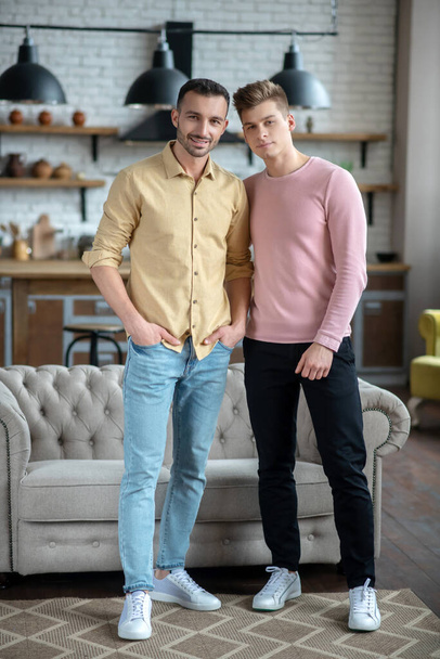 Two young men standing smiling happily and looking good - Fotografie, Obrázek