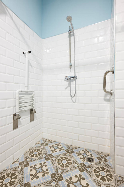 Модерн душ для людей з обмеженими можливостями в біло-блакитному тоні
 - Фото, зображення