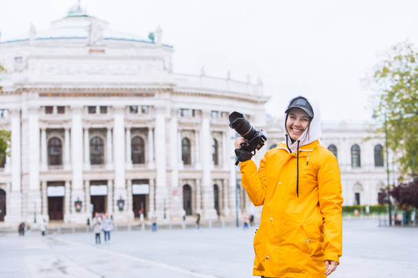 fiatal csinos nő fotós professzionális kamera előtt régi opera épület Bécs Ausztria - Fotó, kép