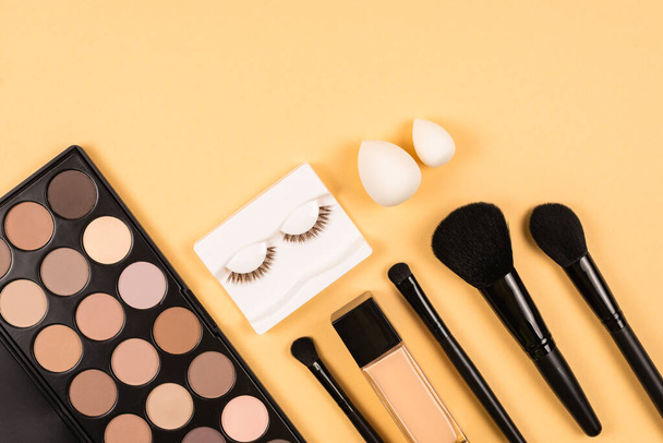 Professional makeup products with cosmetic beauty products, eye shadows, eye lashes, beauty blender, foundation,  brushes and tools. - Photo, Image
