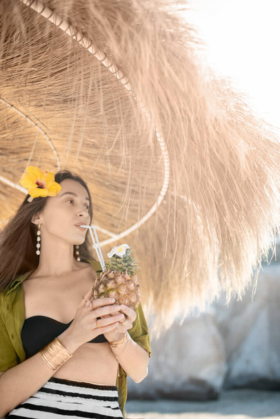 Женщина с экзотическим коктейлем на пляже курорта
 - Фото, изображение