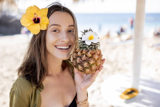 Summer girl with pineapple fruit at the beach resort - Foto, imagen