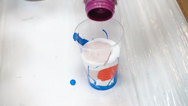 Mieszanie farb akrylowych w plastikowej filiżance - Materiał filmowy, wideo