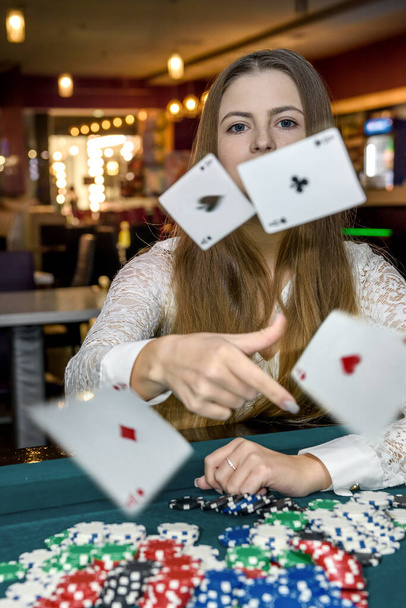 молода жінка кидає гральні карти в казино
 - Фото, зображення