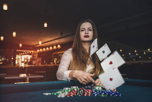 Beautiful woman in casino throwing playing cards - Photo, Image
