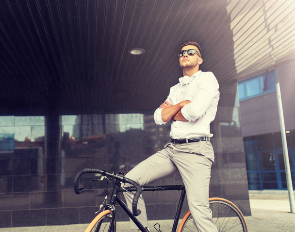 man with bicycle and headphones on city street - Фото, зображення