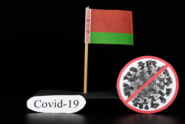 Nationale vlag van Belarus met cel van covid-19 en woord coronavirus. Snelle verspreiding van ziekten wereldwijd. Covid-2019 is een sterkere griep die senioren en zieken treft. Gevaarlijk en agressief. - Foto, afbeelding