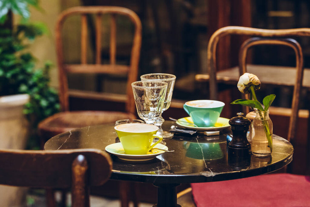 view of restaurant cafe table with tea mugs and flower copy space - Фото, изображение