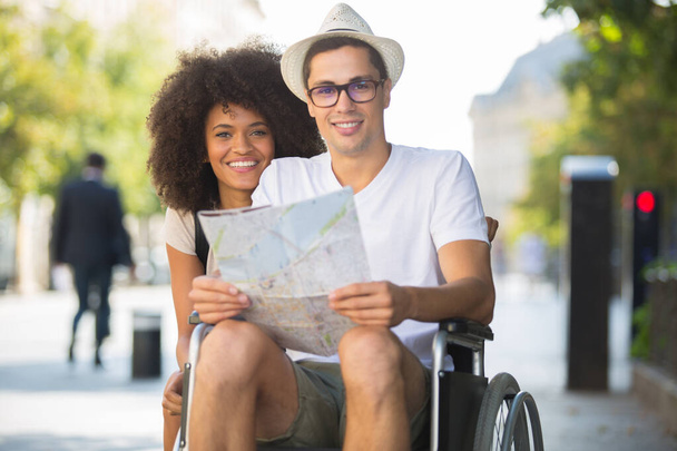 handicapped man in wheelchair and girlfriend on holidays - Fotoğraf, Görsel
