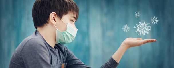 boy in medical face protection mask indoors on blue background - Zdjęcie, obraz