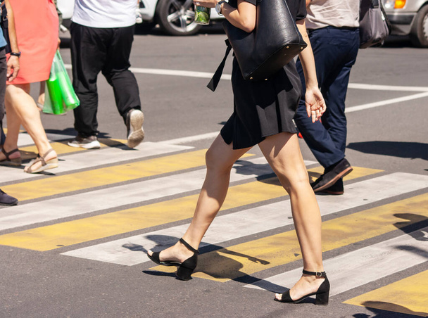 pedestrians crossing the road at a crosswalk in the city on sunny summer day - Foto, imagen