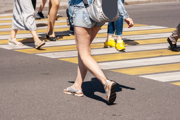 piesi przejeżdżający przez ulicę na przejściu granicznym w mieście w słoneczny letni dzień - Zdjęcie, obraz