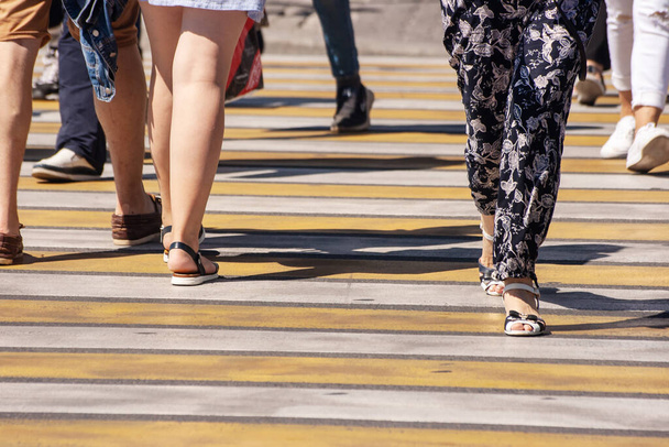 люди перетинають вулицю в пішохідному переході в сонячний літній день
 - Фото, зображення