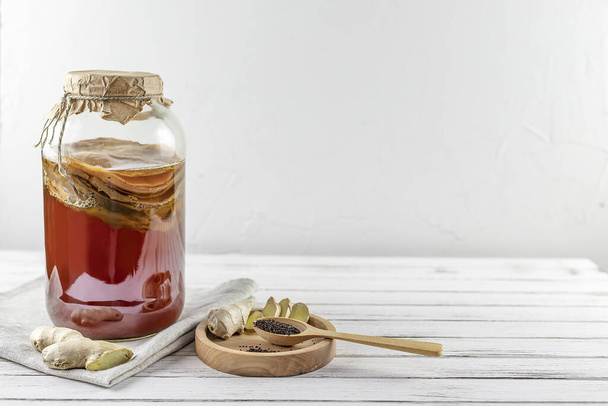 Kombucha superalimento pro biótico bebida de hongos de té en botella de vidrio y frasco con jengibre, té sobre fondo blanco. espacio de copia
 - Foto, imagen
