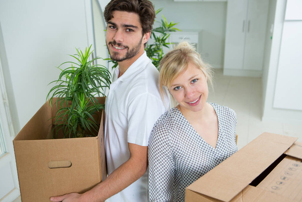 Ζευγάρι μετακομίζει σε νέο σπίτι και ξεπακετάρει κουτιά - Φωτογραφία, εικόνα