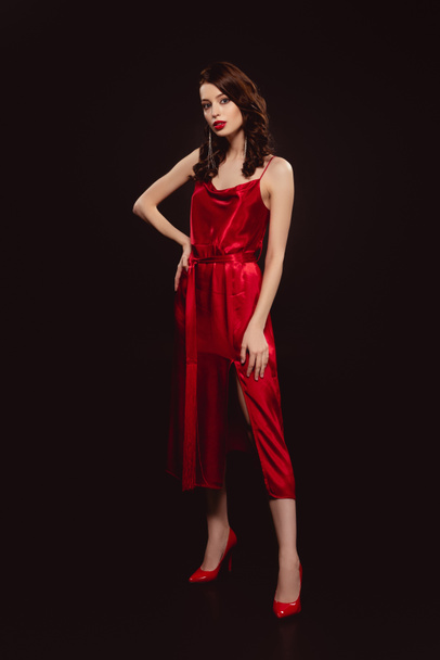 Full length of beautiful woman in red dress looking at camera isolated on black - Zdjęcie, obraz