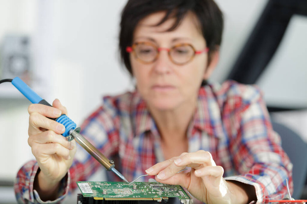 young female tech or engineer repairs electronic equipment - Foto, Imagem