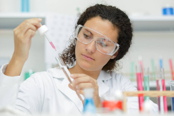 woman doctor with reaction tube and pipette during examination - Φωτογραφία, εικόνα