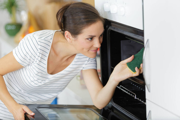 woman cleaning inside an oven - Foto, imagen