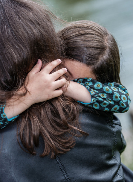 Expressive portrait of pretty girl hugging her mother - Fotó, kép