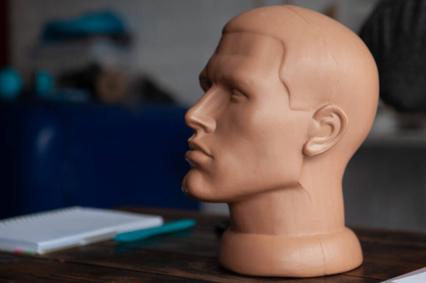 Мужская голова манекена на столе в студии
 - Фото, изображение