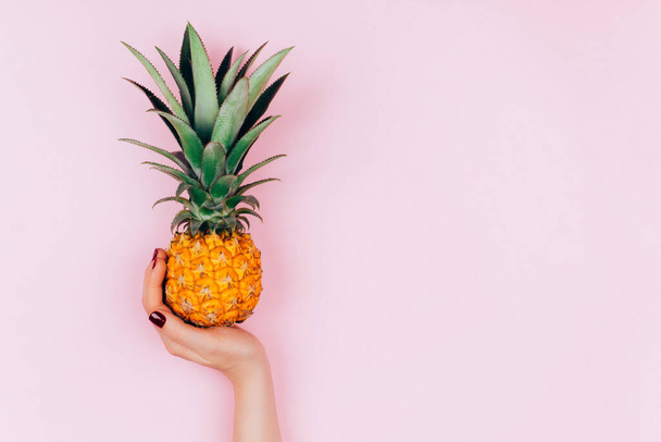 Hands with pineapple on stylish pink background. - 写真・画像