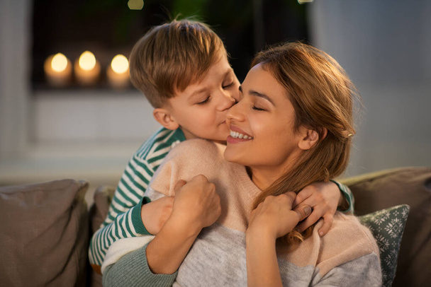 glückliche Mutter und Sohn umarmen und küssen sich zu Hause - Foto, Bild