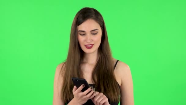 Girl asks for information on the network via phone on green screen - Footage, Video