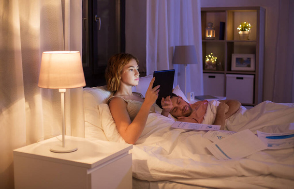 woman with tablet computer working in bed at night - Photo, Image
