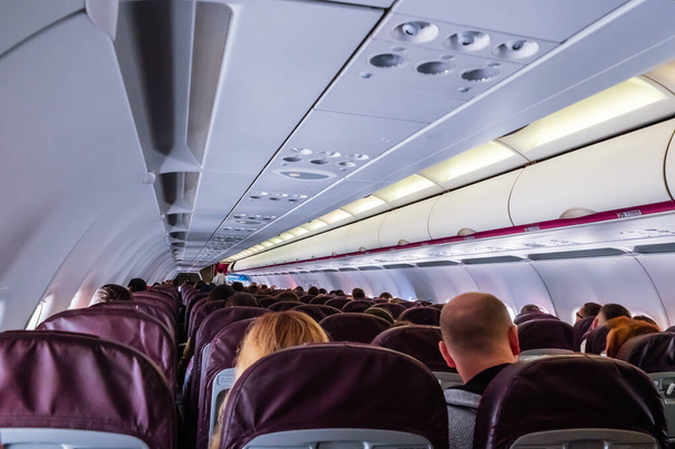 Az üléseken ülő utasokkal rendelkező repülőgép belseje. - Fotó, kép