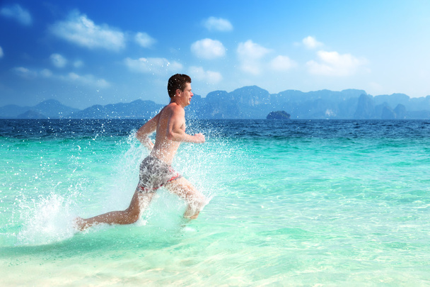 running man in water of tropical sea - 写真・画像