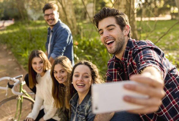 Group of students in the park having fun together makign a selfie - Foto, Imagem