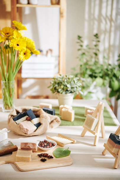 Сушені бутони троянд, листя і квіти для виготовлення мильних смуг на столі в майстерні
 - Фото, зображення