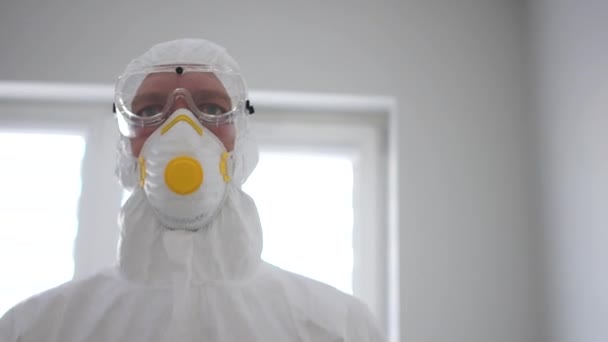 Medic in a protective suit and mask goes into an isolation chamber. Pandemic threat, coronavirus treatment, coronavirus vaccine - Filmagem, Vídeo