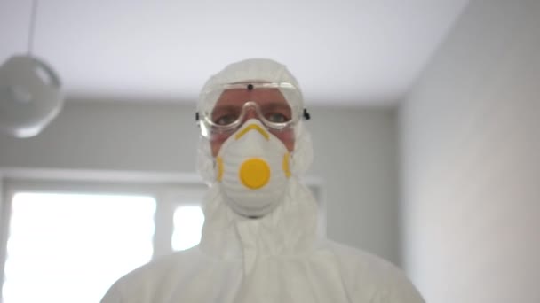 Coronavirus protection, pandemic threat. Close portrait of a man in a protective insulating suit and mask - Felvétel, videó