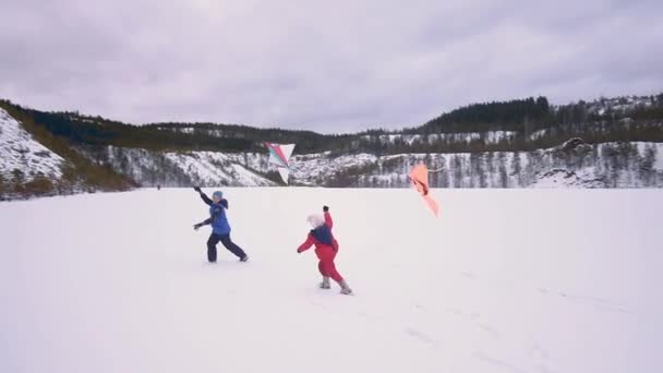 children run with a kite. Winter landscape - Footage, Video