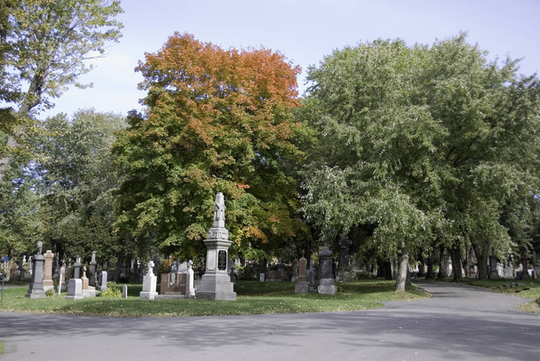 MONTREAL CANADA - OCTOBER 11 2011: Monument in Notre-Dame-des-Neiges Cemetery with colorful autumn trees. Is the largest cemetery in Canada and the third-largest in North America - Foto, Imagen