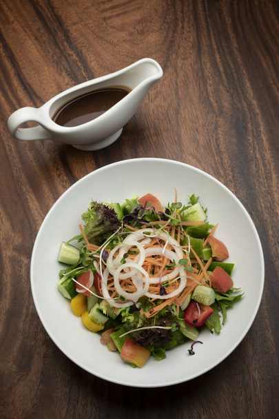 fresh organic mixed vegetable vegan Garden Salad with Vinaigrette sauce on wooden table - Foto, Imagem