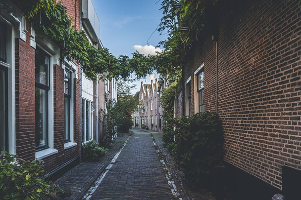 A narrow route through brick buildings during daytime - Foto, Imagen