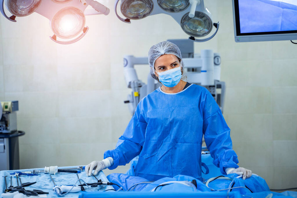 Chirurg in operatiekamer met operatieapparatuur. Medisch team voert operatie uit. - Foto, afbeelding