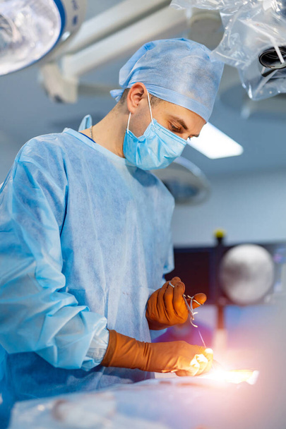 Process of surgery operation using medical equipment. Surgeon in operating room with surgery equipment - Photo, image
