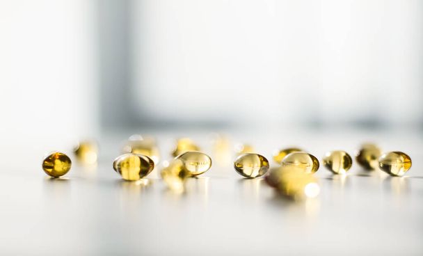 Farmaceutische, branding en wetenschap concept - Vitamine D en gouden Omega 3 pillen voor gezonde voeding, visolie voedingssupplement pil capsules, gezondheidszorg en geneeskunde als apotheek achtergrond - Foto, afbeelding