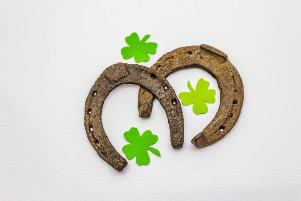 Cast iron metal horse horseshoes isolated on white background. Felt clover leaves, good luck symbol, St.Patrick's Day concept, horse accessories. Template, mockup - Photo, Image