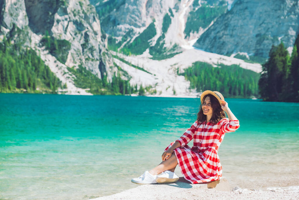 женщина сидит на пляже горного озера летний сезон живописный вид на ландшафт
 - Фото, изображение