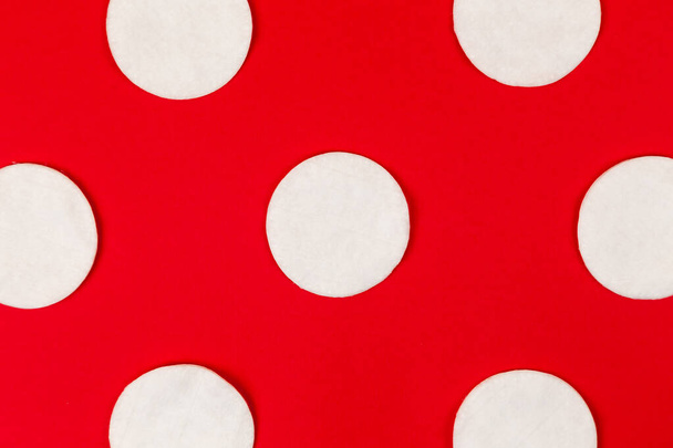 Modèle de tampons en coton avec des ombres dures sur un fond rouge
. - Photo, image