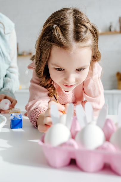 selective focus of cute kid near chicken eggs and mother  - 写真・画像
