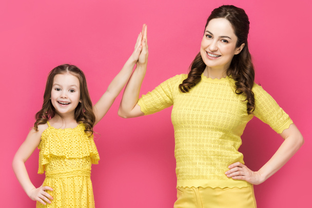 glücklich Frau gibt High Five zu Tochter isoliert auf rosa  - Foto, Bild