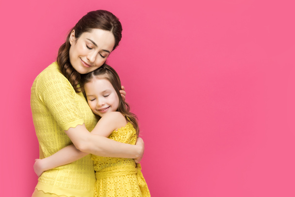 joyeux mère et fille avec les yeux fermés étreignant isolé sur rose
  - Photo, image