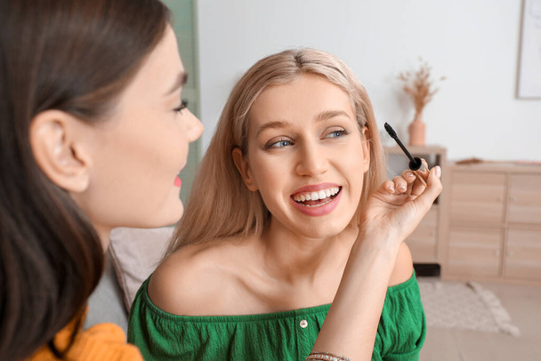 Beautiful young women applying makeup together at home - Photo, image
