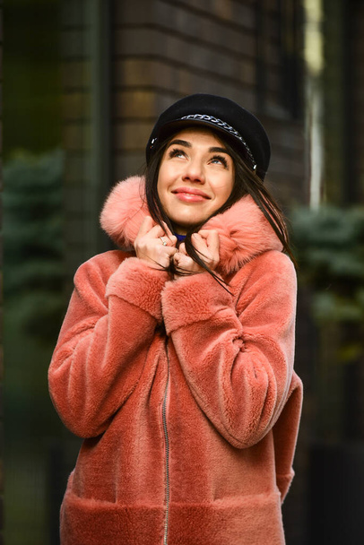 Feeling free and happy. Autumn or winter look. beautiful woman walking in pink coat. wearing trendy hat headwear. street style. spring summer trend. Fashionable woman in pink fur coat. cold season - Photo, image
